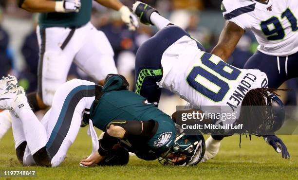 Quarterback Carson Wentz of the Philadelphia Eagles is hit by Jadeveon Clowney of the Seattle Seahawks during the NFC Wild Card Playoff game at...