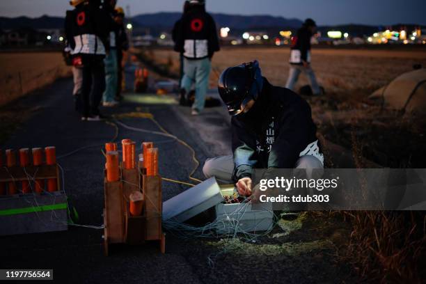 hombre adulto medio preparando fuegos artificiales en preparación para un evento o festival de celebración - explosives fotografías e imágenes de stock