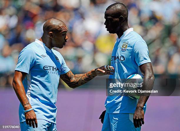 Nigel de Jong of Manchester City speaks with teammate Mario Balotelli before he scored on a penalty kick against Los Angeles Galaxy during the...