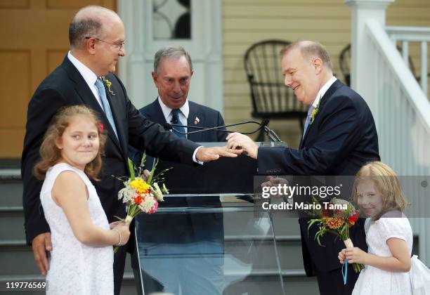 John Feinblatt and Jonathan Mintz exchange rings while marrying with their daughters Maeve and Georgia as New York Mayor Michael Bloomberg officiates...