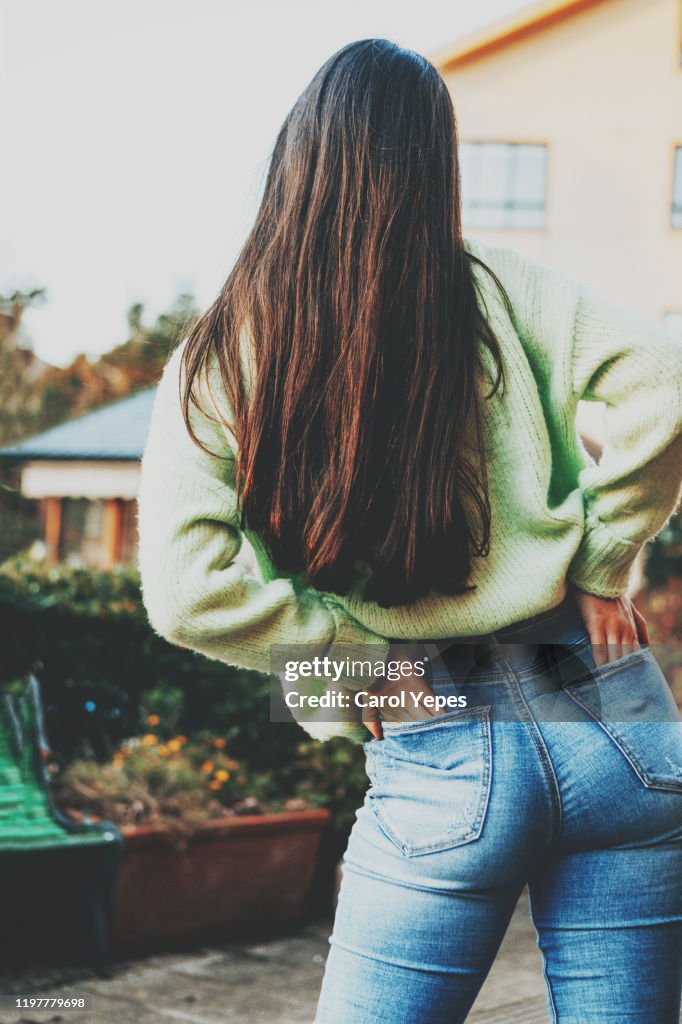 Rear view young teen in blue jeans.