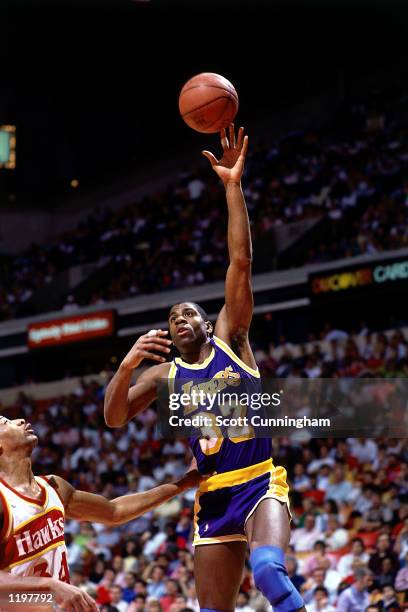 Magic Johnson of the Los Angeles Lakers goes for a hook-shot against the Atlanta Hawks in the 1986 season during the NBA game in Atlanta, Georgia....