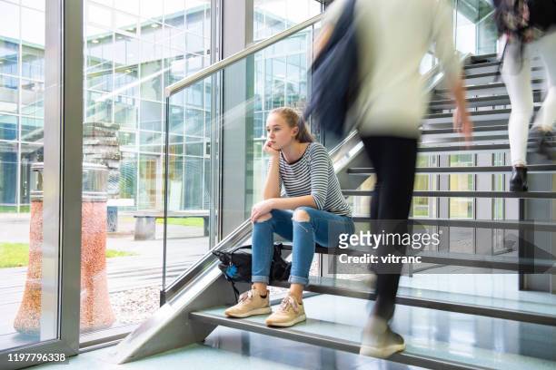 triste colegiala sentada sola en la escalera - boy sad fotografías e imágenes de stock