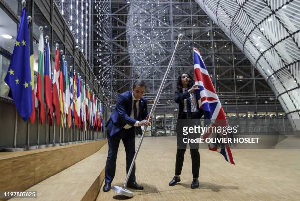 Council staff members remove the United Kingdom's flag from the European Council building in Brussels on Brexit Day, January 31, 2020. - Britain...