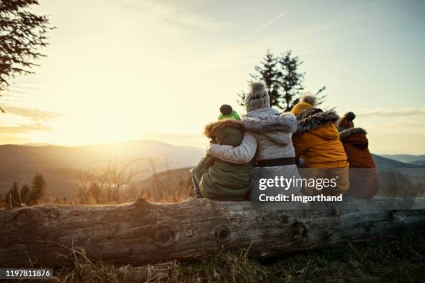 mother and kids enjoying sunset in mountains - roupa quente imagens e fotografias de stock