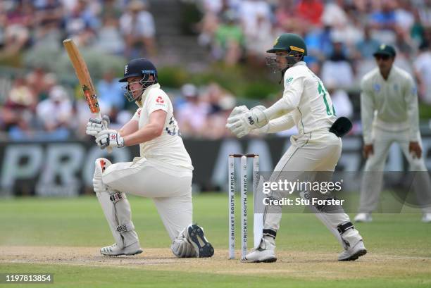 England batsman Dominic Sibley sweeps to the boundary watched by Quinto de Kock during Day Four of the Second Test between South Africa and England...