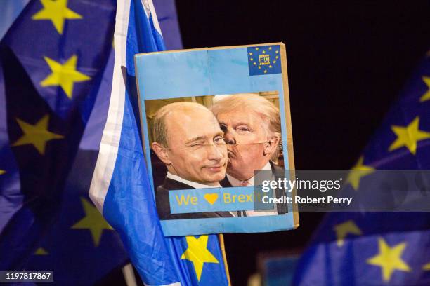 Poster showing Donald Trump kissing Vladimir Putin is held up at the Missing EU Already Anti-Brexit Rally outside the Scottish Parliament at Holyrood...