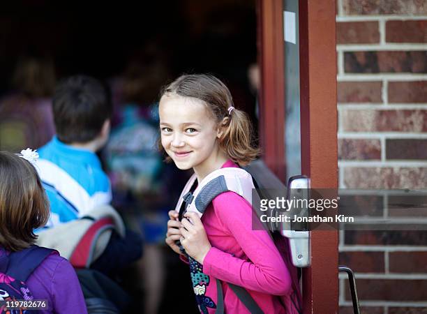 first grader holds door at school. - entering photos et images de collection