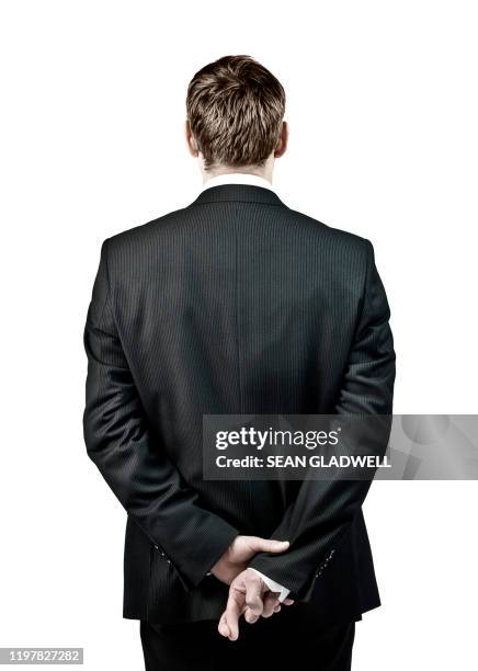 man with fingers crossed behind back - suspicion employee stock pictures, royalty-free photos & images