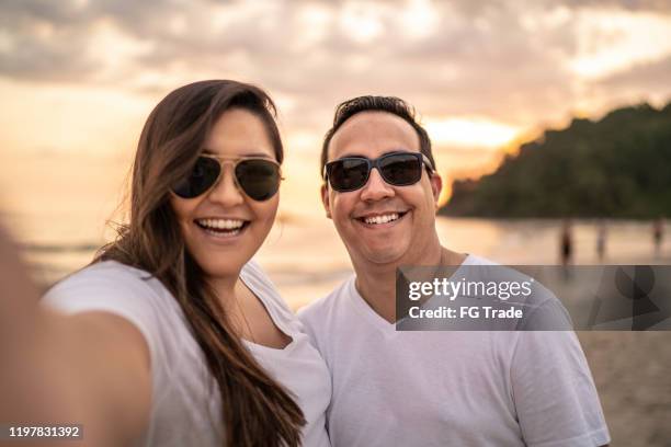 couple taking a selfie on the beach - male model selfie stock pictures, royalty-free photos & images
