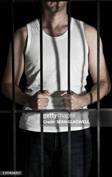 man in cell wearing white vest - prison door stock pictures, royalty-free photos & images