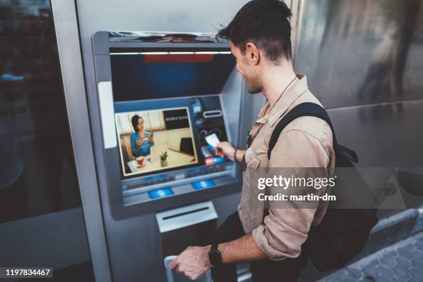 man withdrawing money - man atm smile stock pictures, royalty-free photos & images