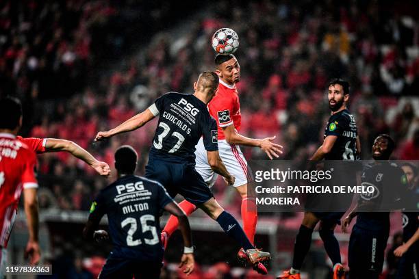 Benfica's Brazilian forward Carlos Vinicius heads the ball with Belenenses' Portuguese defender Goncalo Silva during the Portuguese league football...