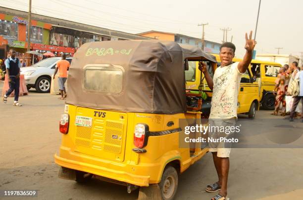 Young tricycle driver hail down for more passengers, along Ijaiye road, Aguda, Lagos on January 31, 2020.