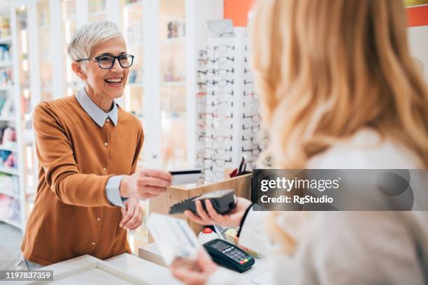 mature woman buying a medicine at the pharmacy - contactless stock pictures, royalty-free photos & images