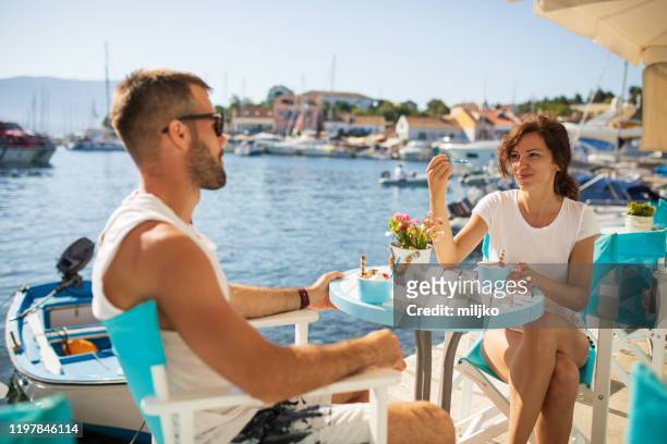 couple sitting in coffee shop near marina at seaside - cefalónia imagens e fotografias de stock