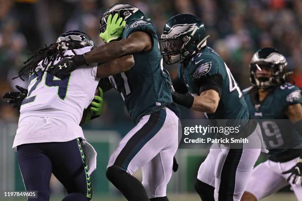 Running back Marshawn Lynch of the Seattle Seahawks rushes past Philadelphia Eagles defenders during their NFC Wild Card Playoff game at Lincoln...