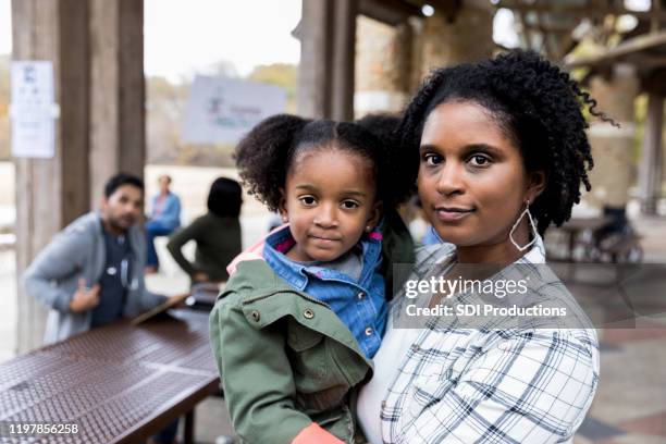 mid adult alleenstaande moeder houdt jonge dochter bij free clinic - serious stockfoto's en -beelden