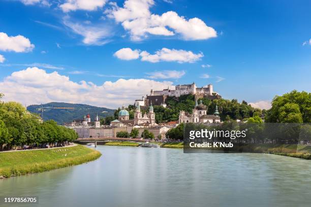 awesome, beautiful view of old town and the fortification castle or fortress hohensalzburg on the hill, salzburg austria, europe with clear blue sky - salzburg stock-fotos und bilder