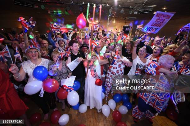 Brexit supporters wave Union flags as the time nears 11 O'Clock at a Brexit Celebration party at Woolston Social Club in Warrington, north west...