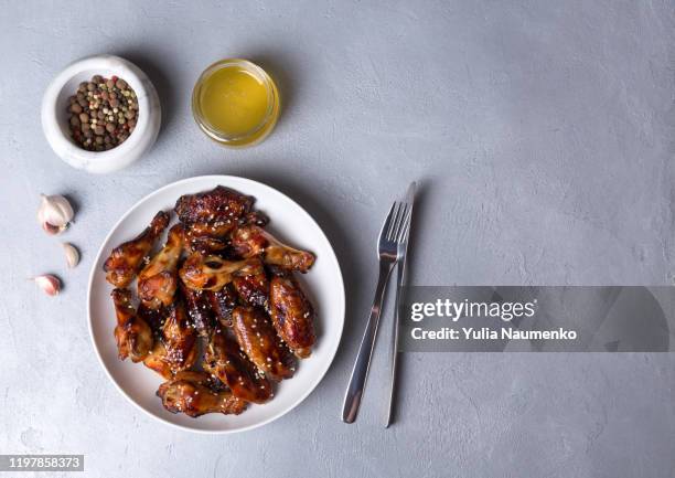 spicy chicken wings with teriyaki sauce and sesame seeds in a white plate on a dark background.top view, copy space. - cooked turkey white plate imagens e fotografias de stock