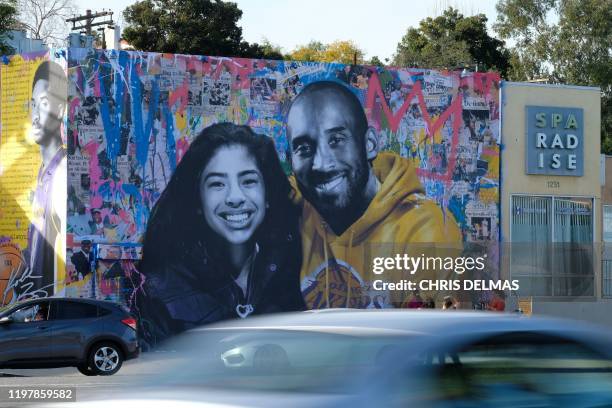 Cars drive by a new mural by French artist Mr. Brainwash picturing Kobe Bryant and his daughter Gigi is seen in Los Angeles on January 31, 2020. /...