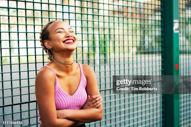 laughing woman with arms folded - young women only stock-fotos und bilder