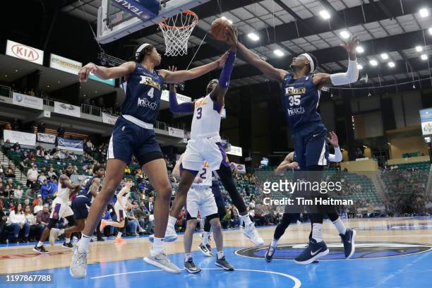 Norense Odiase of the Northern Arizona Suns attempts to grab a rebound against Moses Brown of the Texas Legends and Aric Holman of the Texas Legends...