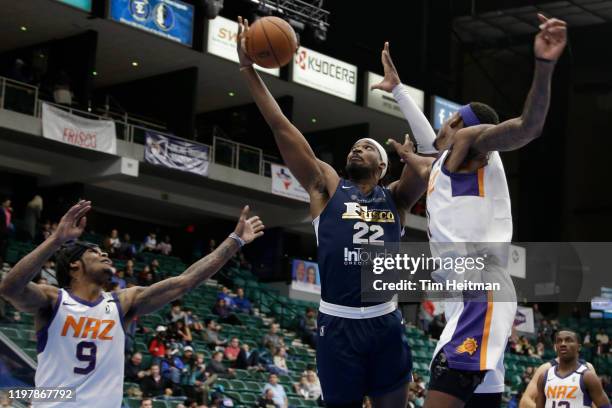 Chad Brown of the Texas Legends drives against Tariq Owens of the Northern Arizona Suns and Ahmed Hill of the Northern Arizona Suns during the third...