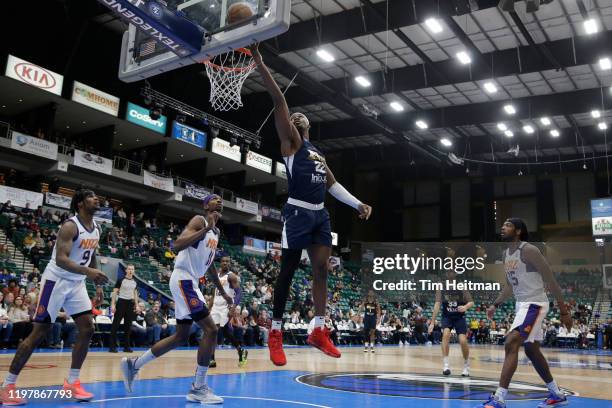 Chad Brown of the Texas Legends drives against Tariq Owens of the Northern Arizona Suns and Ahmed Hill of the Northern Arizona Suns during the third...