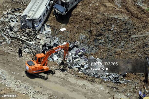 This aerial photo taken on July 24, 2011 shows workers clearing the wreckages after two high-speed trains collided the night before in the town of...