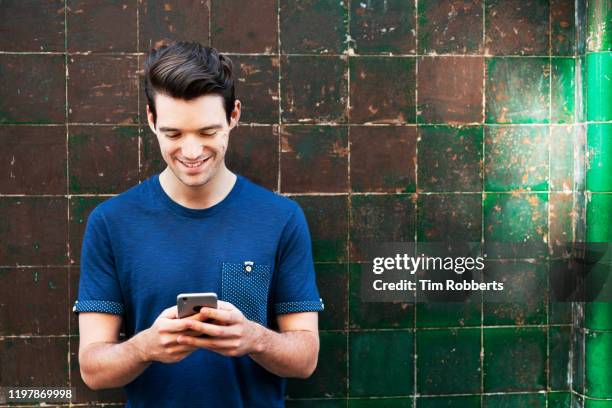 man using smart phone next to tiled wall - look down stock pictures, royalty-free photos & images