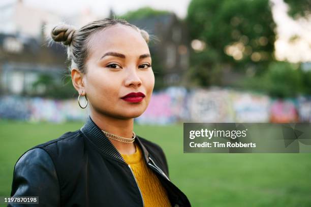 portrait of woman in city park - rode lippenstift stockfoto's en -beelden