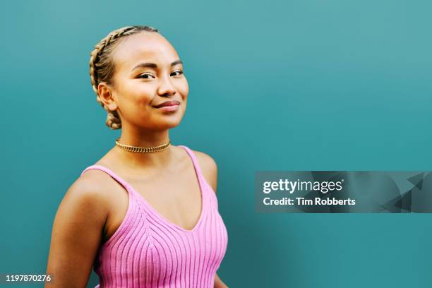 portrait of woman next to blue wall - mischief woman stock pictures, royalty-free photos & images