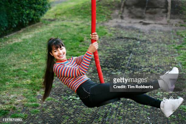 woman on swing slide - swing stock pictures, royalty-free photos & images