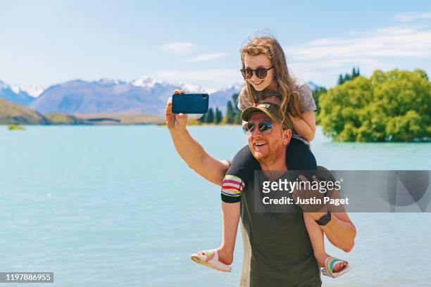 father and daughter taking selfie by lake tekapo - nz summer bildbanksfoton och bilder
