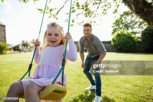 swings with dad! - playground swing stock pictures, royalty-free photos & images