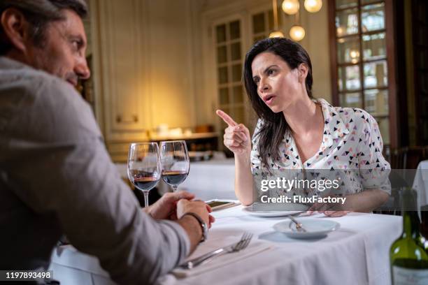 bossy wife talking to her husband during valentine's day date - bossy wife stock pictures, royalty-free photos & images