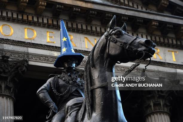 Traffic cone painted in the colours of the EU flag perches atop the head of a statue of the Duke of Wellington outside the Gallery of Modern Art in...