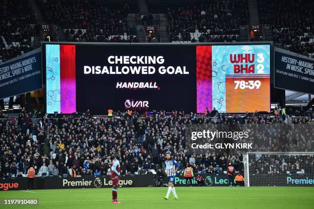 Giant screen shows the VAR being checked for a disallowed goal, which was overturned allowing during Brighton's English striker Glenn Murray to...