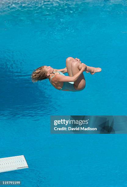 woman springboard diver in a tuck position. - woman curled up stock pictures, royalty-free photos & images