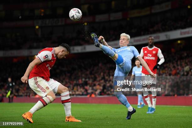 Ezgjan Alioski of Leeds United clears the ball under pressure from Granit Xhaka of Arsenal during the FA Cup Third Round match between Arsenal FC and...