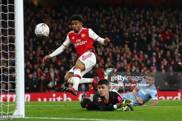 Reiss Nelson of Arsenal scores his side's first goal past Illan Meslier of Leeds United during the FA Cup Third Round match between Arsenal FC and...