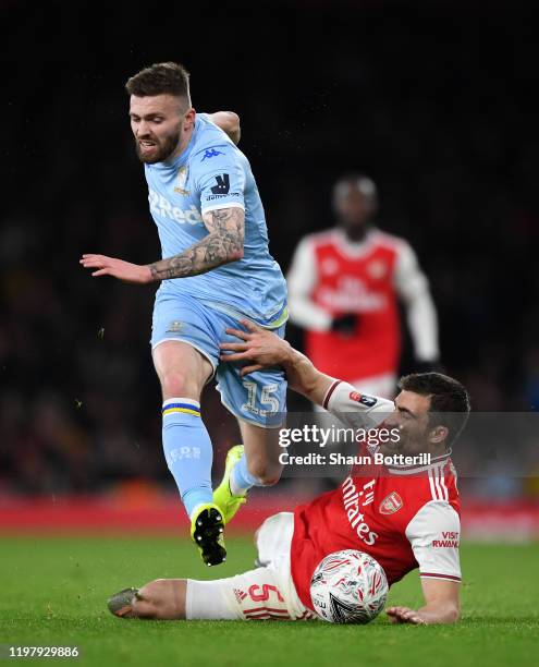 Stuart Dallas of Leeds United is tackled by Sokratis Papastathopoulos of Arsenal during the FA Cup Third Round match between Arsenal FC and Leeds...