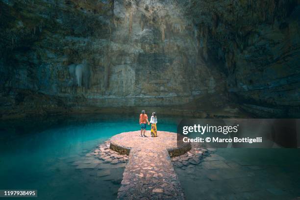 couple holding hands exploring a cenote in yucatan peninsula, mexico - yucatánhalvön bildbanksfoton och bilder