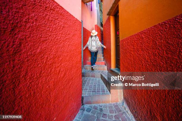 tourist exploring a narrow alley in guanajuato, mexico - ciudadanos mexicanos fotografías e imágenes de stock