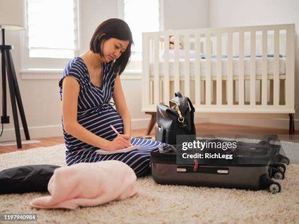 zwangere japanse vrouw in een kinderkamer - diaper bag stockfoto's en -beelden