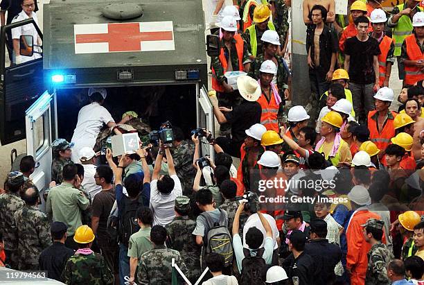 Two-and-a-half year old girl is carried into an ambulance from the scene of the crash involving two trains, as rescue workers and media look on on...