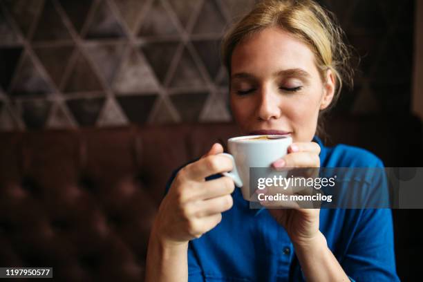 beautiful blond woman enjoying coffee in a cafe - espresso drink stock pictures, royalty-free photos & images