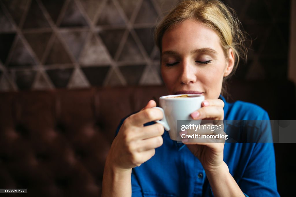 Beautiful blond woman enjoying coffee in a cafe